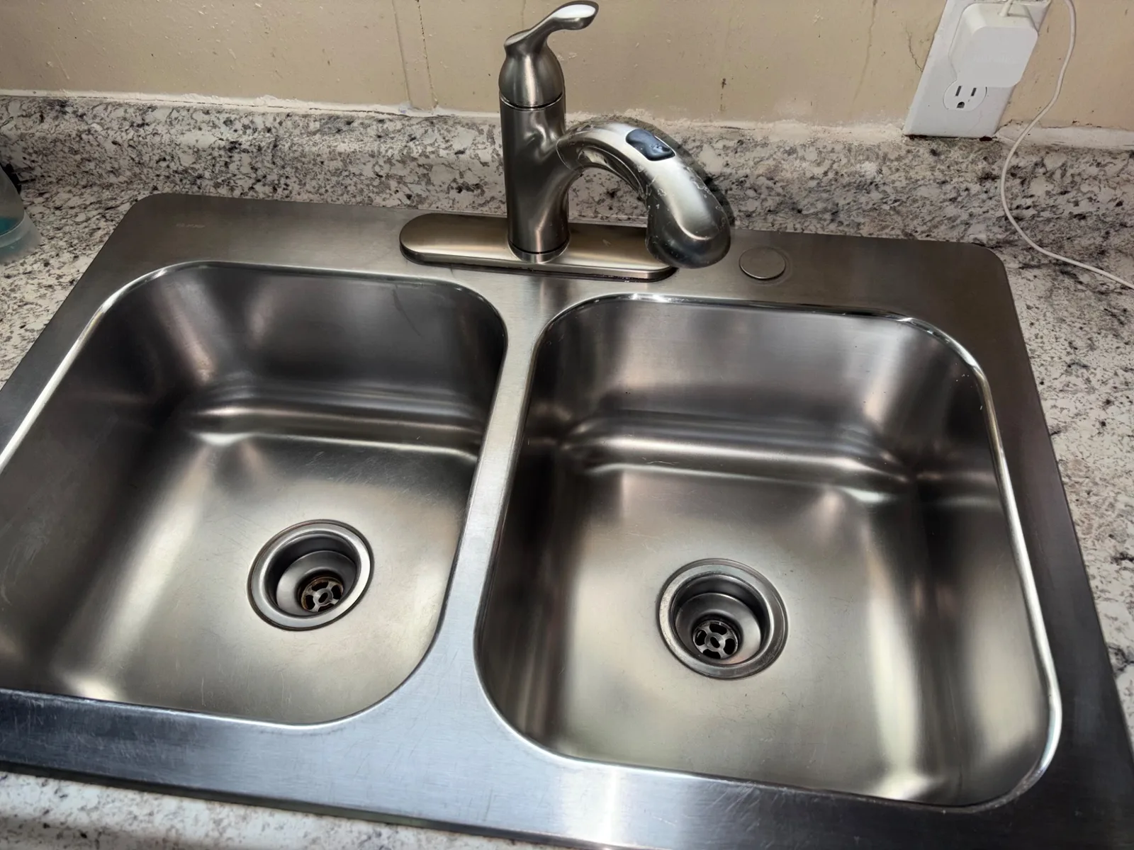 The same stainless steel kitchen sink after detailed cleaning, bright and polished
